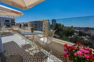 a balcony with a table and chairs and flowers at Lavender Boutique Hotel in Ramallah