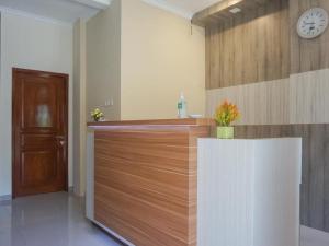 a kitchen with a counter and a clock on the wall at RedDoorz Plus @ Karangploso in Karangploso