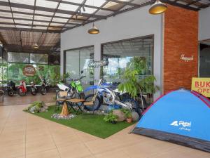 a garage with a tent and motorcycles in it at RedDoorz Plus @ Karangploso in Karangploso