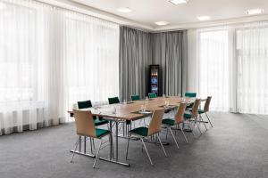 a conference room with a long table and chairs at Spark by Hilton Essen City Centre in Essen