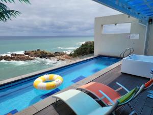 a swimming pool with chairs and a beach at Youngdeok Bell Mar Poolvilla in Yŏngdŏk