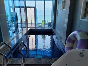 a swimming pool in a bathroom with a view of the ocean at Youngdeok Bell Mar Poolvilla in Yŏngdŏk