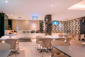 a restaurant with tables and chairs and a kitchen at Hotel 88 Mangga Besar Raya 120 Jakarta By WH in Jakarta