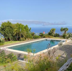 a swimming pool with the ocean in the background at Ocean View Cottage in Ponta do Pargo