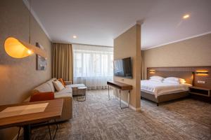 a hotel room with a bed and a couch at Apartmány Kramer in Opava