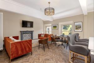 a living room with a table and chairs and a fireplace at Marske Hall, Yorkshire Dales in Marske