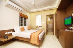 1 dormitorio con 1 cama y TV en The Summit Luxury Apartments - Monthly Accommodation en Chennai
