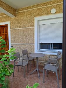 a patio with a table and chairs and a window at Hills Villa in Vlorë