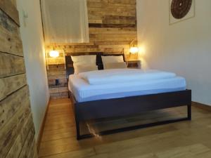 a bedroom with a bed with a wooden wall at Au Grimp'Han in Han-sur-Lesse