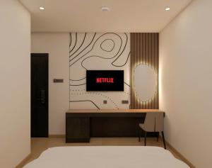 a bedroom with a bed and a tv on a wall at Dragon Hotel in Rạch Giá