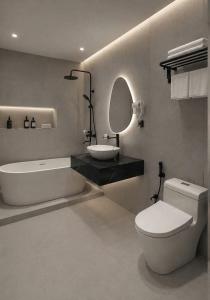 a bathroom with a tub and a toilet and a sink at Dragon Hotel in Rạch Giá