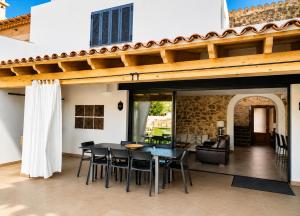 a dining room with a table and chairs on a patio at Can Roig in Ses Salines