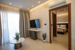 a hotel room with a television and a bed at Matsi Suites in Faliraki