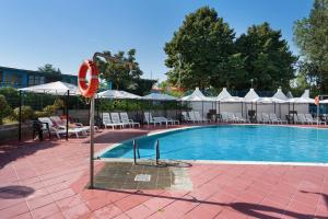 a swimming pool with tables and chairs and umbrellas at Camping La Chiocciola a Capannole in Capannole
