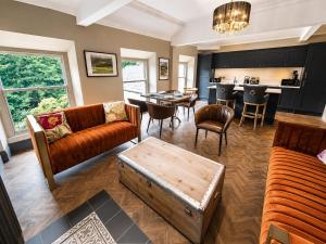 a living room with couches a table and a kitchen at Marske Hall, Yorkshire Dales in Marske