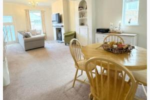 a kitchen and dining room with a table and chairs at Walton Beach 1-Bed Cottage Sleeps 2 with Parking in Walton-on-the-Naze +3 photos