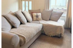 a couch with pillows on it in a room at Walton Beach 1-Bed Cottage Sleeps 2 with Parking in Walton-on-the-Naze