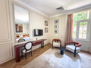 a room with a desk and chairs and a television at AJIRA Zamalek Hotel in Cairo