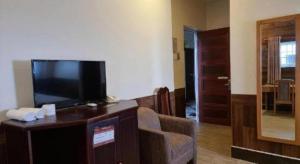 a living room with a flat screen tv and a couch at RUBY HOTEL in Cà Mau