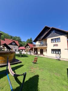 a yard with two baseball bats and a house at Pensiunea Mariana in Bran