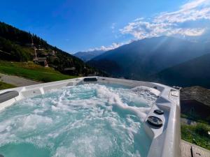 a hot tub with a view of a mountain at Chalet White Peak by Miggins in Grimentz