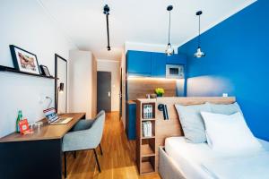 a small apartment with a bed and a desk and a room at Brera Serviced Apartments Ulm in Ulm +44 photos