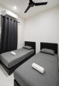 two beds in a bedroom with a ceiling fan at Casaria Beach in Paka