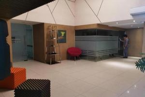a man standing in a room with a red chair at Maxx Hotel Ortigas in Manila
