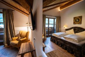 a bedroom with a bed and a chair in a room at Hotel Hartenfels in Lech am Arlberg +145 photos