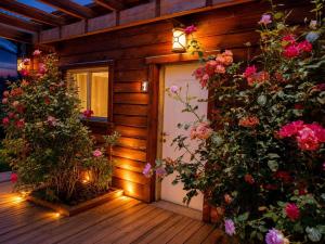 a front door of a wooden house with flowers at BeLev Odem in Odem