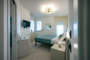 a hotel room with a bed and a television at Milena Suite Apartments in Alghero
