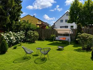 a yard with two chairs and two tables in the grass at Tinyhaus Josie von Tinyhaus Steinhude in Steinhude