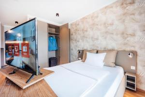 a bedroom with a large white bed with a glass wall at Brera Serviced Apartments Ulm in Ulm