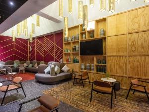a lobby with a couch and a tv and chairs at Ibis Abdelmoumen Casa Centre in Casablanca