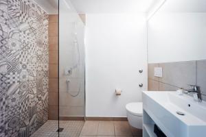 a bathroom with a shower and a sink and a toilet at Brera Serviced Apartments Ulm in Ulm
