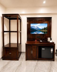 a entertainment center with a flat screen tv in a room at Grand Valley - A Boutique Resort in Mount Abu in Mount Ābu