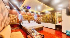 a bedroom with a bed and a couch and a table at Pine View Resort in Gulmarg