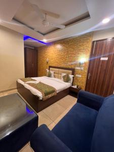 ein Schlafzimmer mit einem Bett und zwei blauen Stühlen in der Unterkunft Hotel Signature Plaza - Near Lajpat Nagar Metro in Neu-Delhi