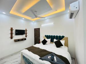 ein Schlafzimmer mit einem Bett und einem Fernseher an der Decke in der Unterkunft Hotel Signature Plaza - Near Lajpat Nagar Metro in Neu-Delhi