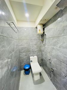 ein Badezimmer mit Toilette und einem blauen Mülleimer in der Unterkunft Hotel Signature Plaza - Near Lajpat Nagar Metro in Neu-Delhi + 16 Fotos