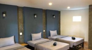 three beds in a room with blue walls at CoCo Tree Resort in Thap Sakae