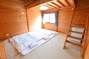 a large bed in a wooden room with a ladder at Haecho County - Camp - Vacation STAY 42289v in Oshite