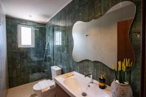 a bathroom with a sink and a mirror on the wall at Matsi Suites in Faliraki +73 photos