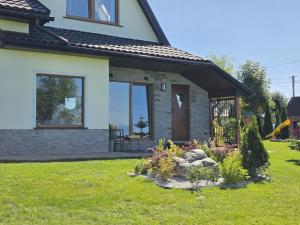 a house with a window and a door in a yard at Apartament Polana No 24 in Bańska Wyżna