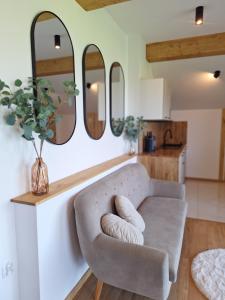 a living room with a couch and three mirrors at Apartament Polana No 24 in Bańska Wyżna +13 photos