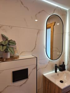 a bathroom with a sink and a mirror at Apartament Polana No 24 in Bańska Wyżna