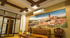 a living room with a couch and a painting on the wall at Eitanic Resort in Ban Don Tako
