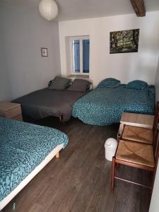 a bedroom with two beds and a table and a window at Sky and Bel Air in Saint-Philbert-de-Bouaine