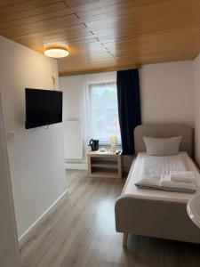 una camera da letto con un letto e una TV a parete di Hotel Rademacher a Wittmund