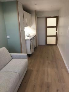 a living room with a couch and a kitchen at Appartement cosy in Les Rousses